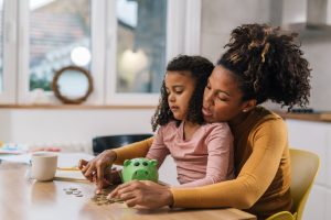 Neutral adult woman with child and coins iStock 1500212360